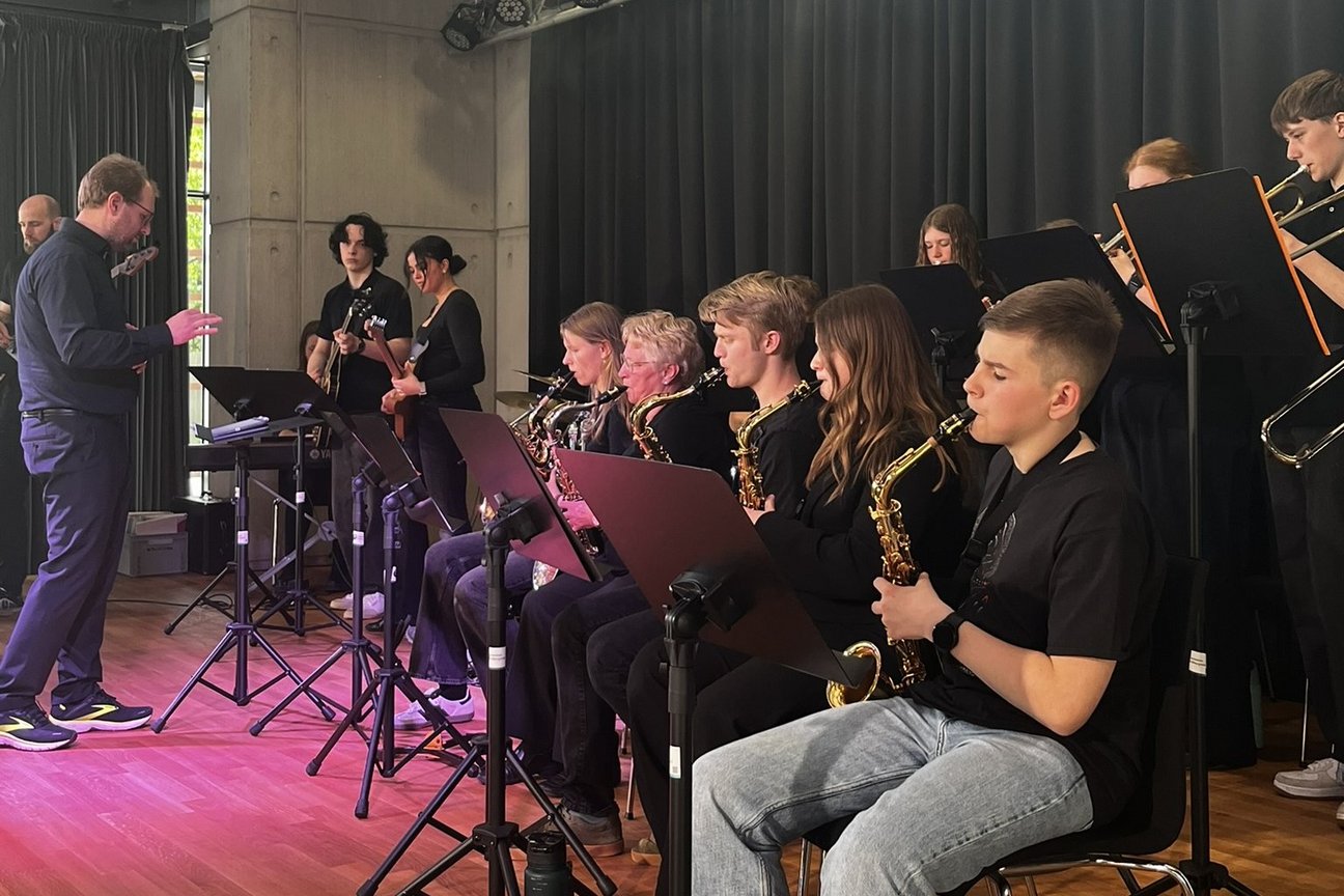 Schülerinnen und Schüler mit Musikinstrumenten auf der Bühne