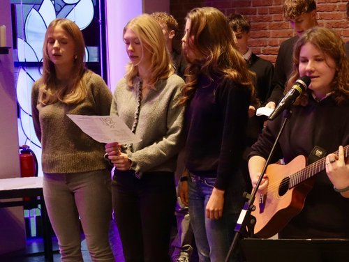 Schülerinnen und Schüler singen und spielen Gitarre