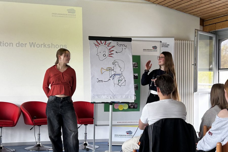 Schülerinnen präsentieren Arbeitsergebnnisse mit einem Flipchart