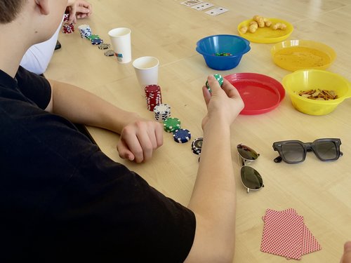 Ein Schüler, der an einem Tisch sitzt und pokert.