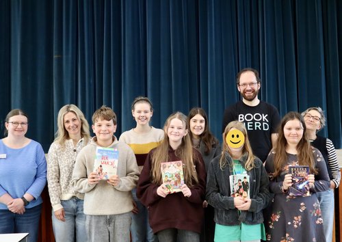 Die Teilnehmerinnen und Teilnehmer am Vorlesewettbewerb zusammen mit den Jury-Mitgliedern beim Gruppenfoto.