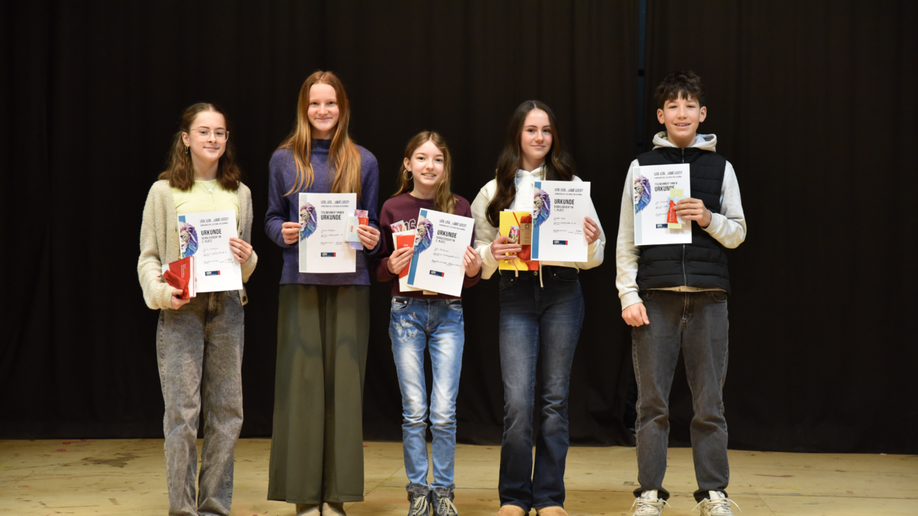 Schülerinnen und Schüler zeigen Urkunden in die Kamera