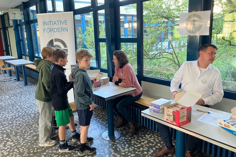 Schülerinnen und Schüler in der Pausenhalle zusammen mit einem Lehrer.