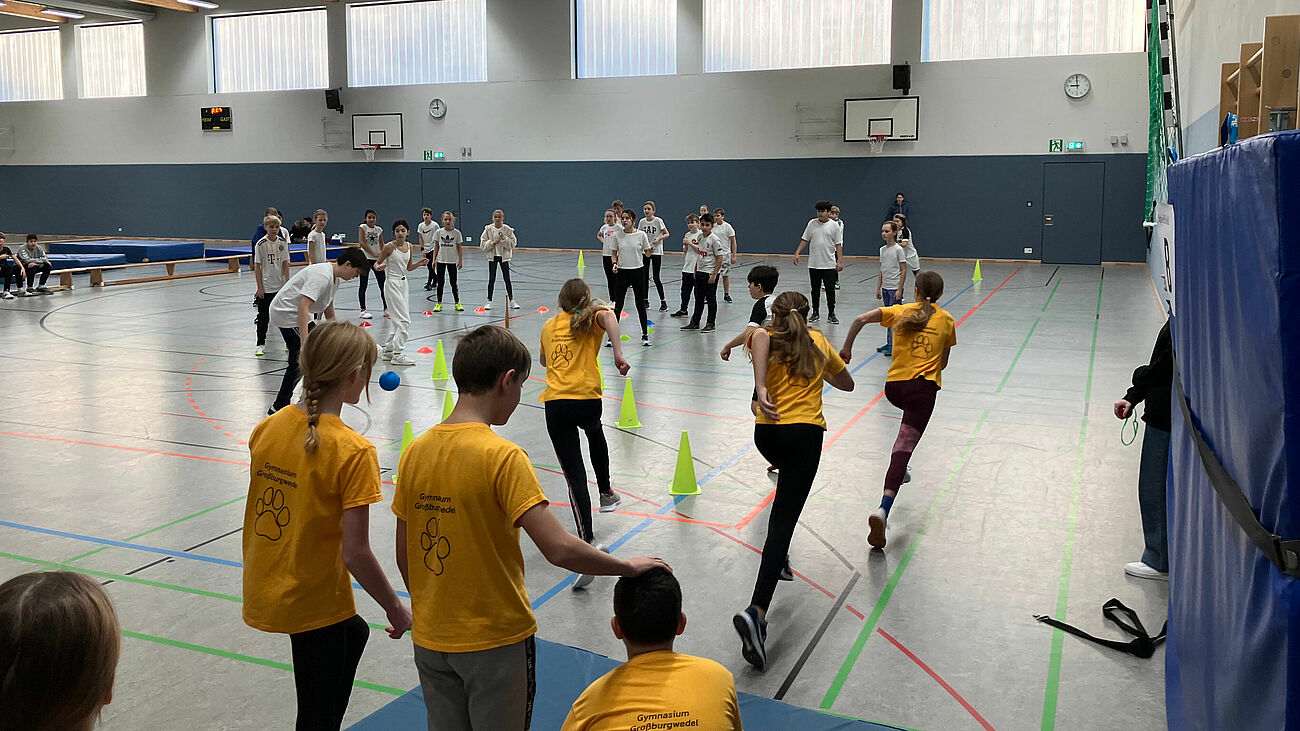 Schülerinnen und Schüler spielen Kegelbrennball