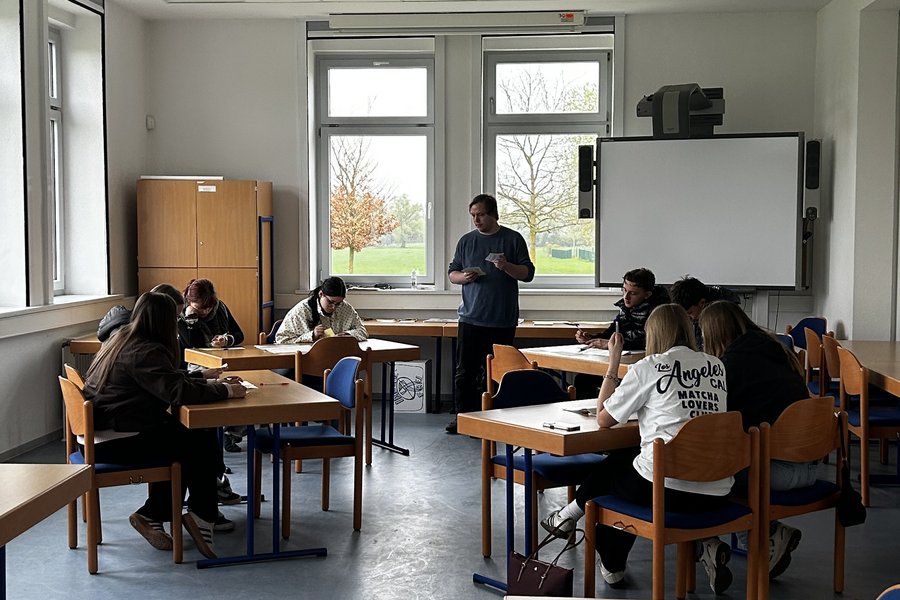 Schülerinnen und Schüler arbeiten an Tischen
