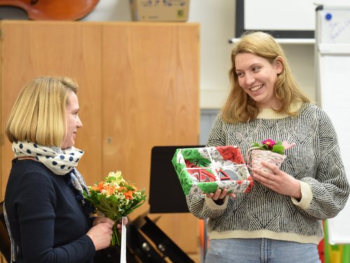 Die Refrendarin bekommt ein Abschiedsgeschenk überreicht.